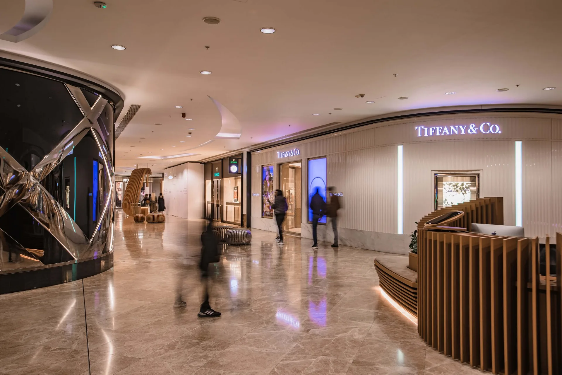 The marble boutique gallery at Port Baku Mall, with the Tiffany & Co. storefront lit at the end of the walkway