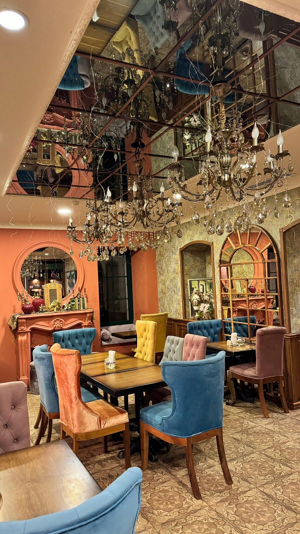 The mirrored-ceiling salon at Merci Baku, with crystal chandeliers and velvet chairs