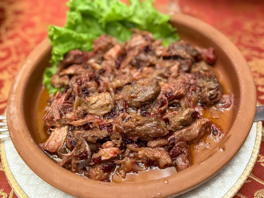 Beef braised with onion and dried cherry, served in an earthenware bowl at Shirvanshah Museum Restaurant.