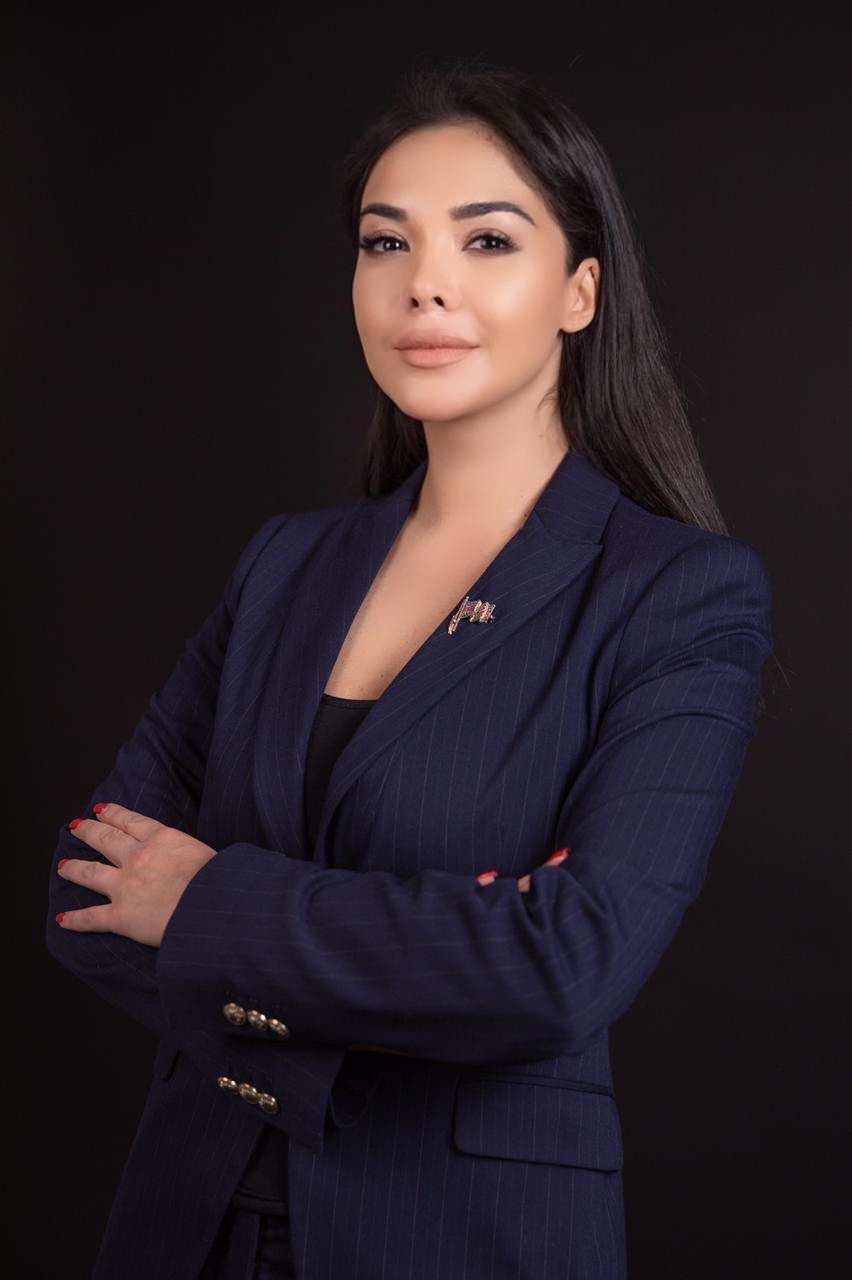 Portrait of Kamila Verdiyeva, founder of Merci Baku, in a navy pinstripe suit