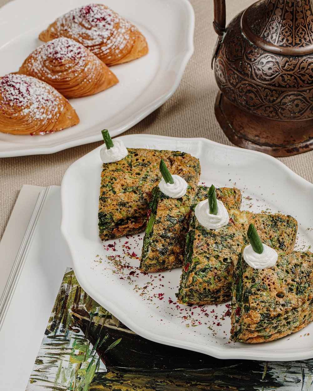 Kükü — Azerbaijani herb omelette with soured cream, beside sweet pastries at Shur Jazz Hall in Baku