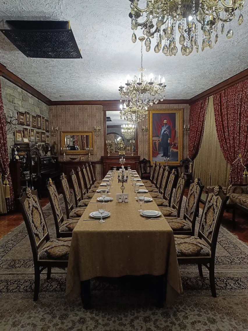 The private dining salon at Shirvanshah Museum Restaurant, Baku — long table, crystal chandeliers and antique portraiture.
