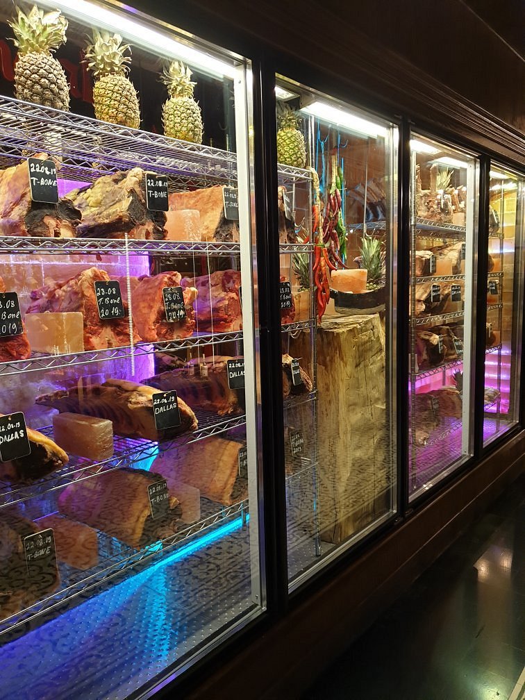 Glass dry-ageing cabinets lined with cuts of beef on Himalayan salt blocks at Mangal Steak House in Baku
