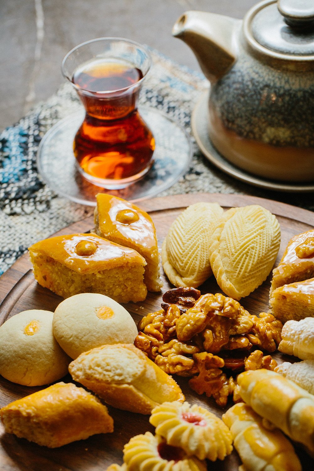 A board of Azerbaijani sweets — pakhlava, shekerbura and walnuts — with a glass of tea at Chayki in Baku