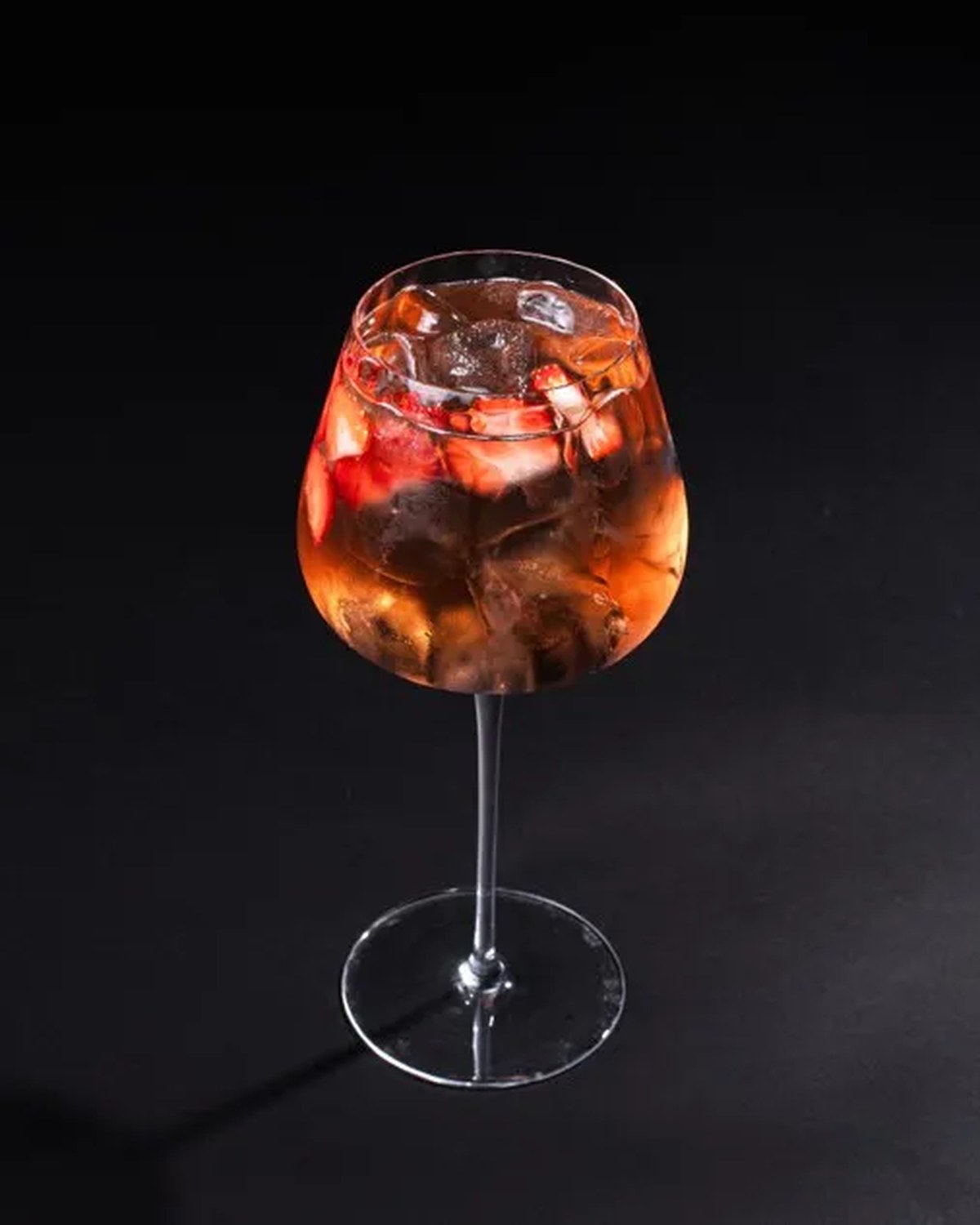 A chilled aperitif served in a stemmed glass against a dark background