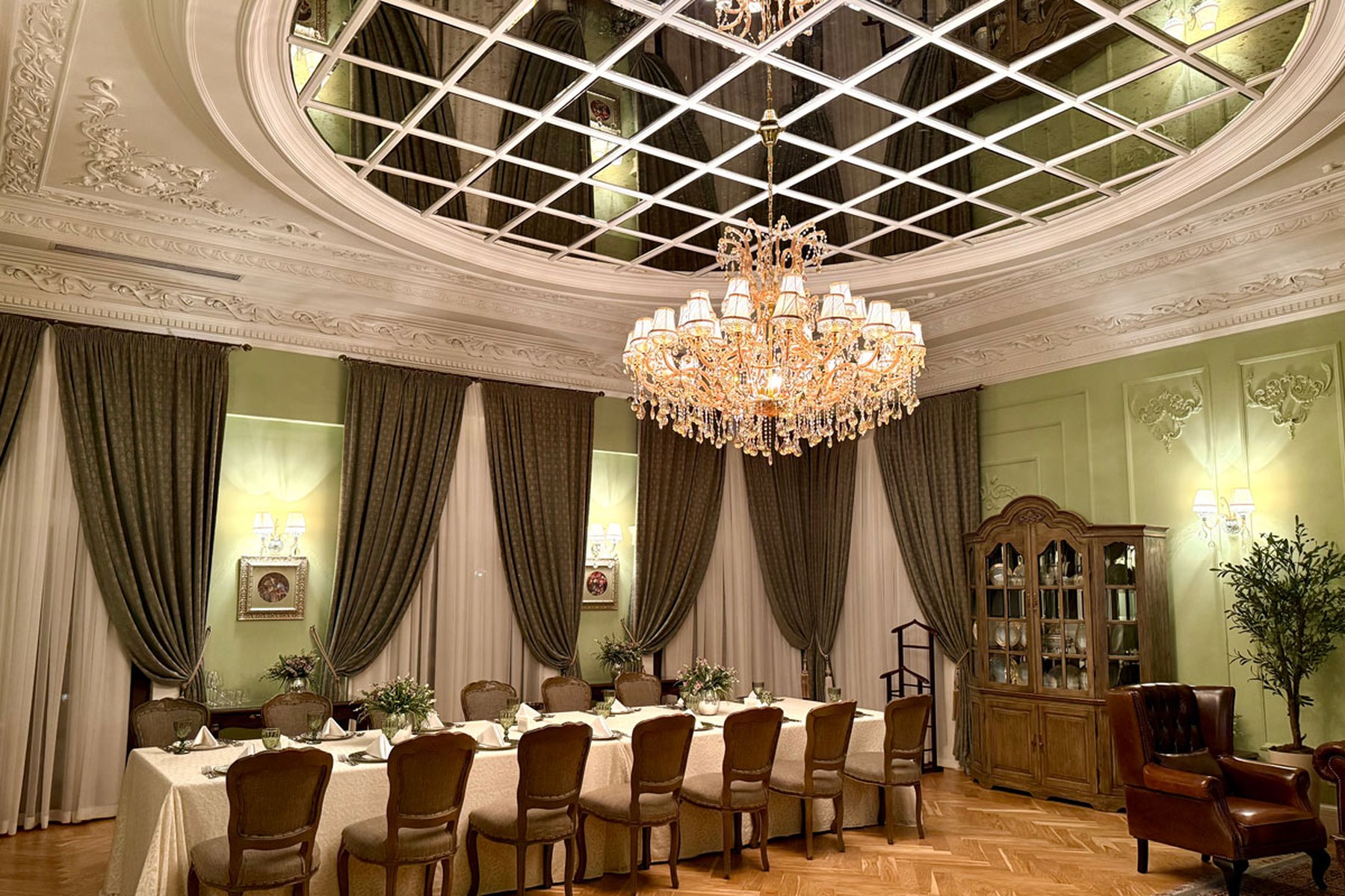 A grand private dining room in Baku with a crystal chandelier and a long table set for service